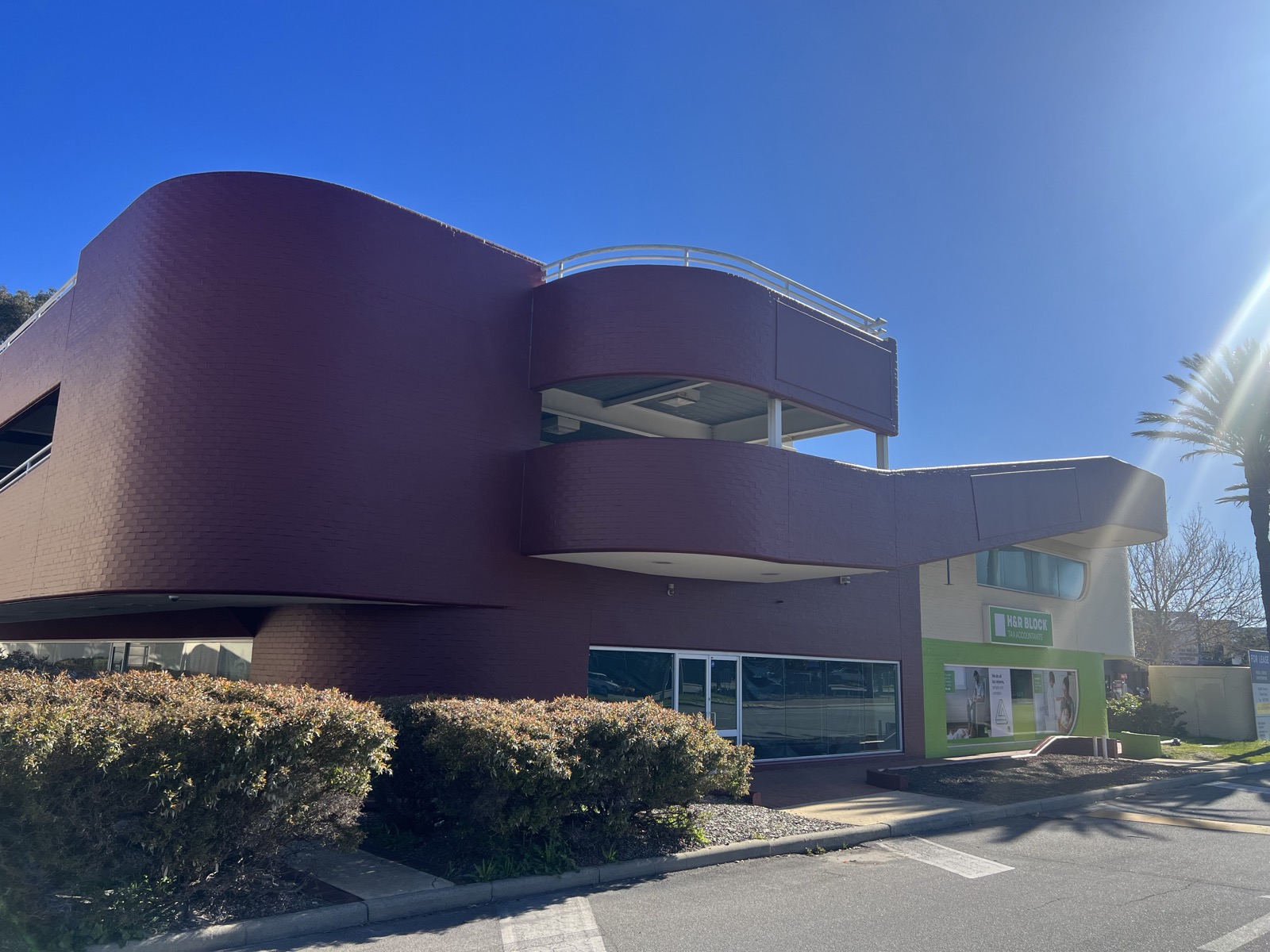 Two-tone commercial facade repainted in maroon and white in Perth